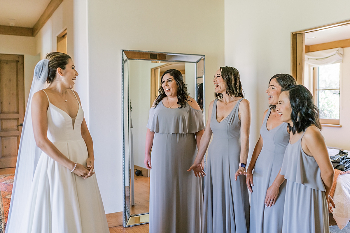 The bridesmaids seeing the bride in her wedding dress for the first time at the San Luis Obispo Mission wedding venue.