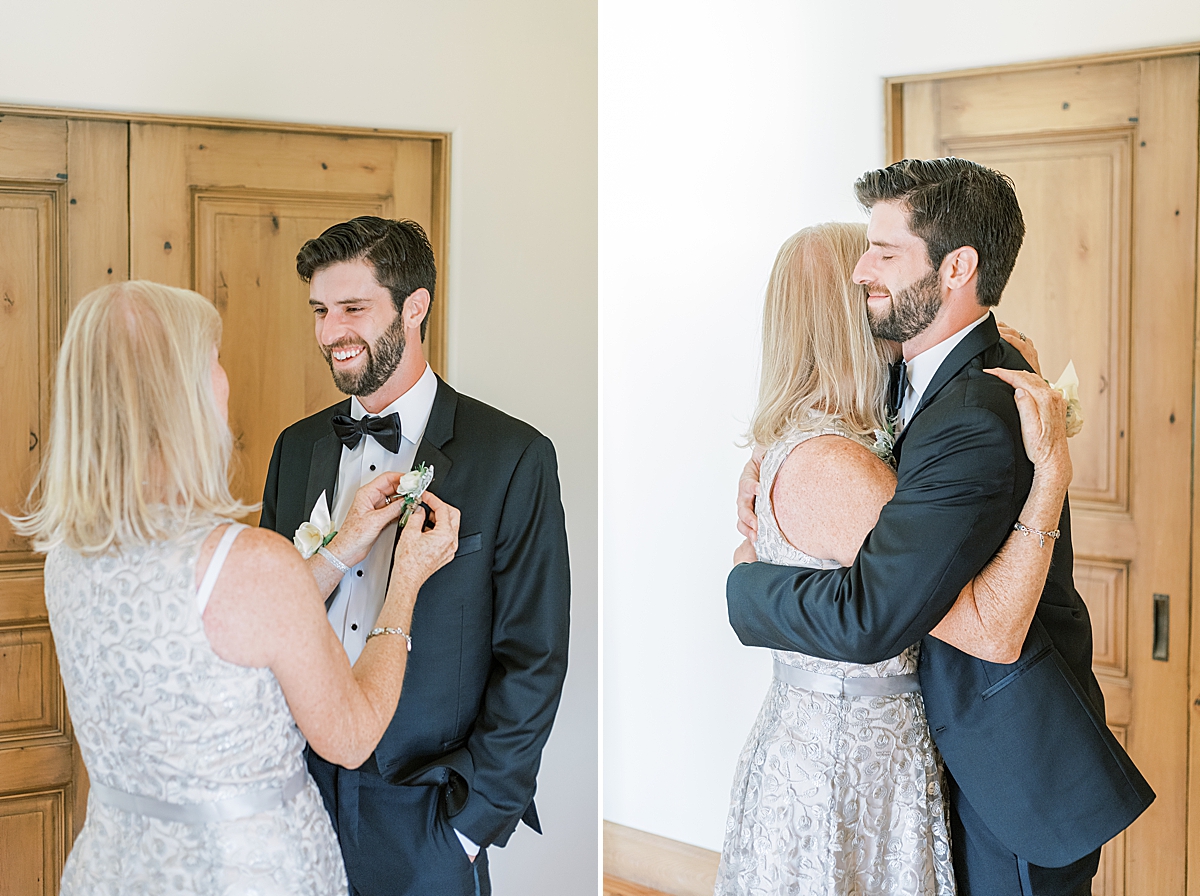 The mother of the groom helps her son with his boutonniere. 