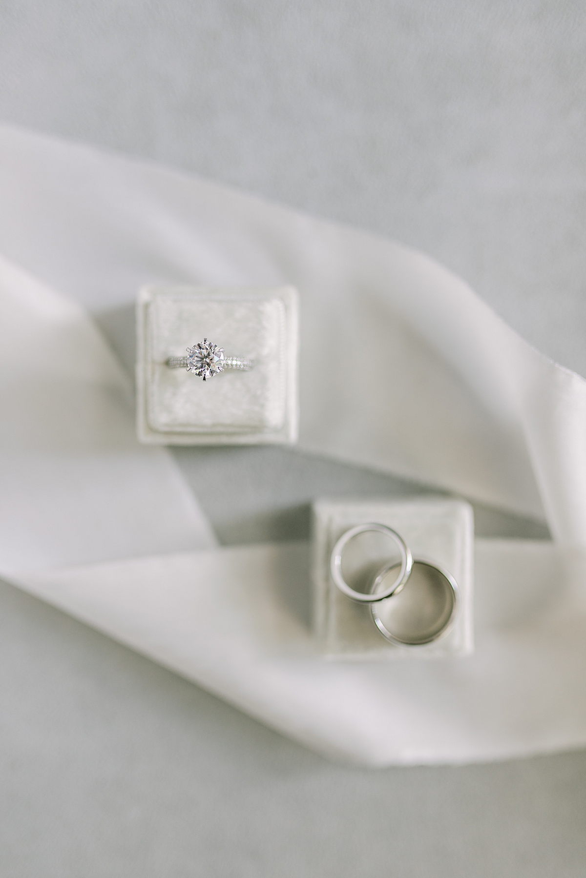 The couple's wedding bands and Erica's engagement ring in a ring box surrounded by white ribbon.