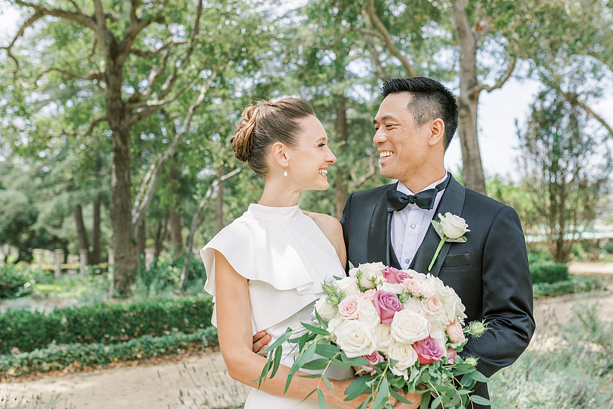 The couple smiling at each other after their first look at Westmont College before their intimate Montecito Church Wedding ceremony just outside Santa Barbara, California.