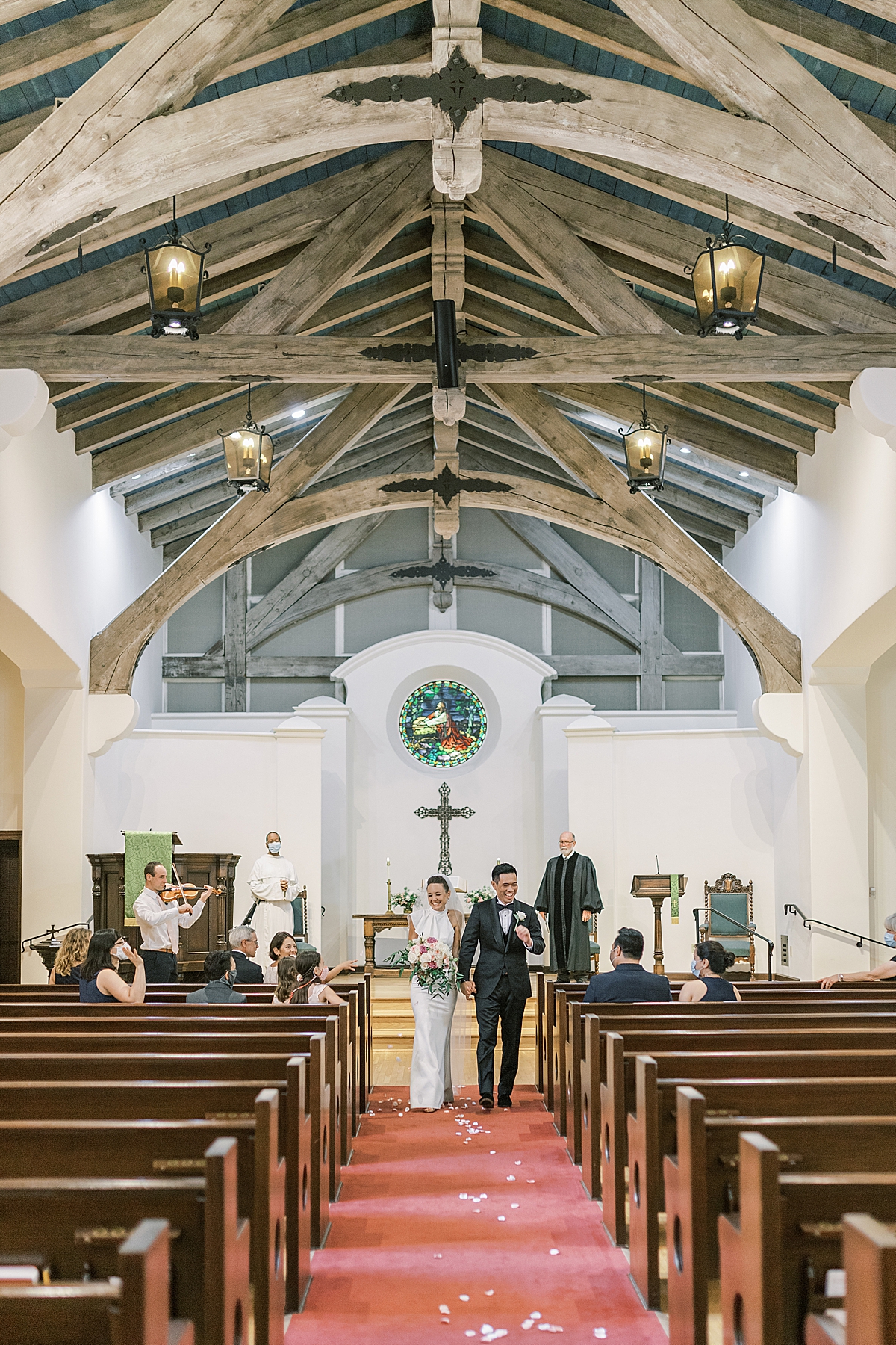 The couple walking down the aisle after being pronounced Mr. and Mrs. at their Montecito Church Wedding.
