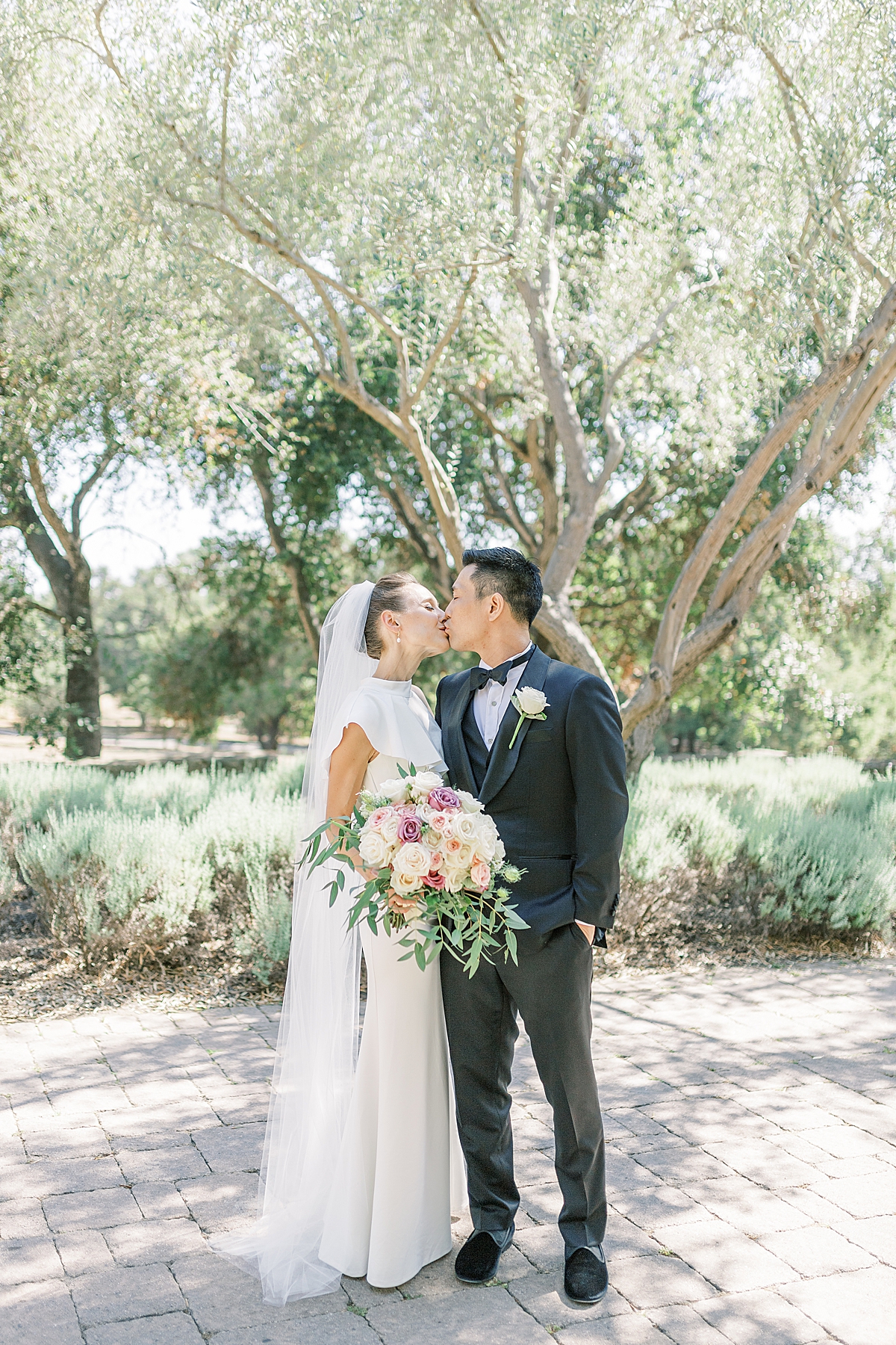 The couple sharing a kiss at the San Ysidro Ranch after their intimate Montecito Church Wedding
