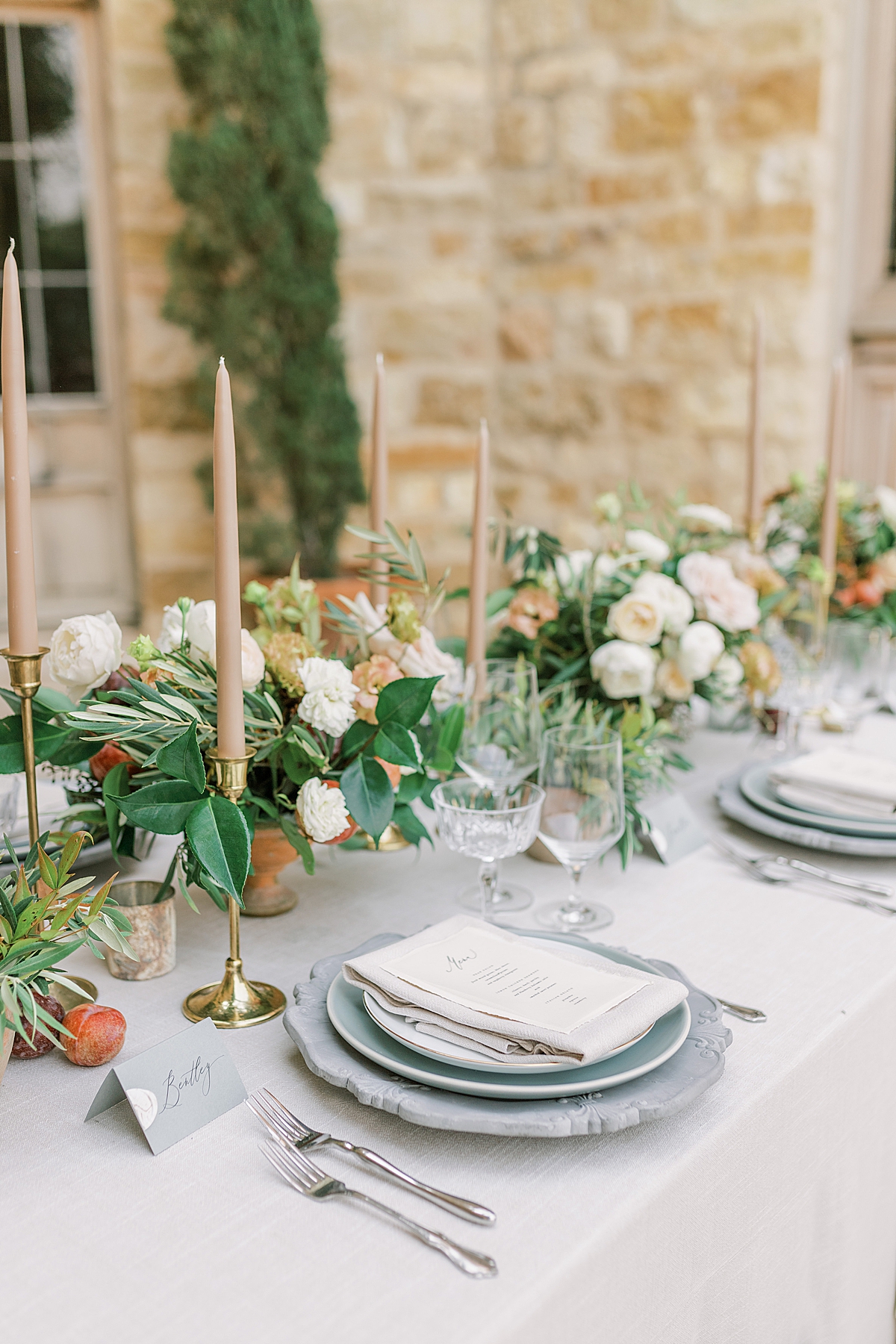 A image of the length of the reception table with multiple place settings and the Sunstone Villa walls in the background.