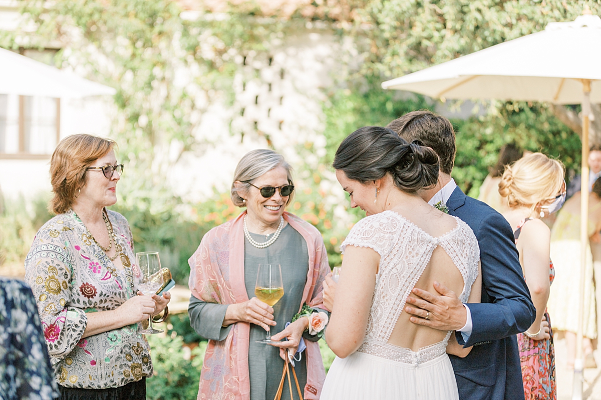 The bride and groom conversing with guests during the cocktail hour of this private estate wedding in Ojai, California