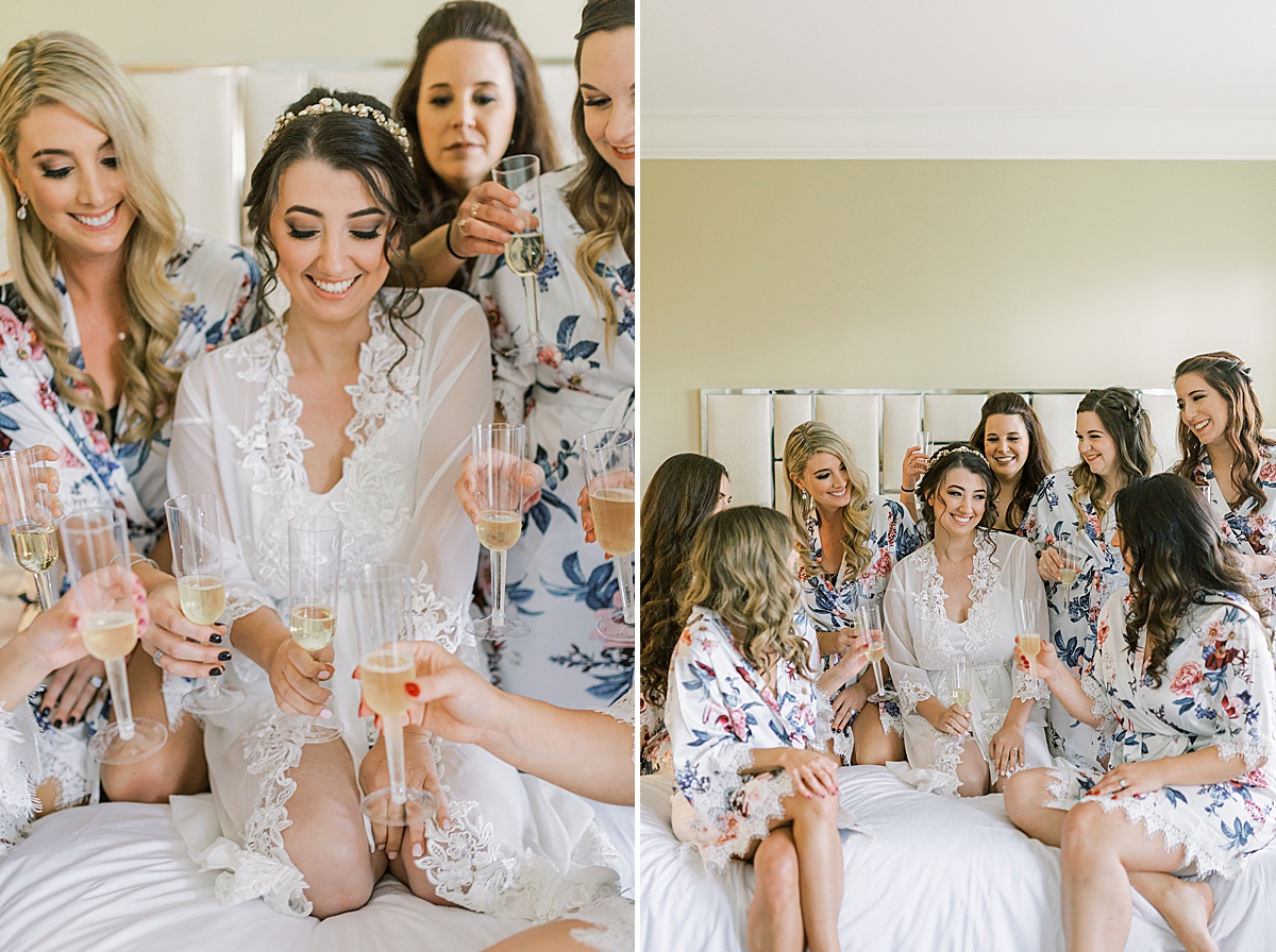 Sofia and her bridesmaids in matching robes on a bed drinking champagne before her Ancient Spanish Monastery Wedding