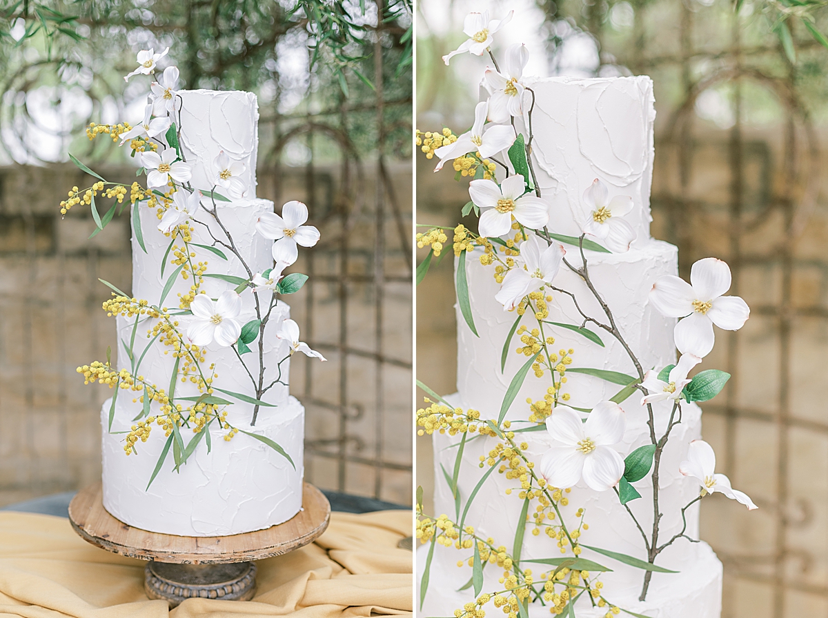 The couple's four-tiered cake with yellow and white florals going up the side.