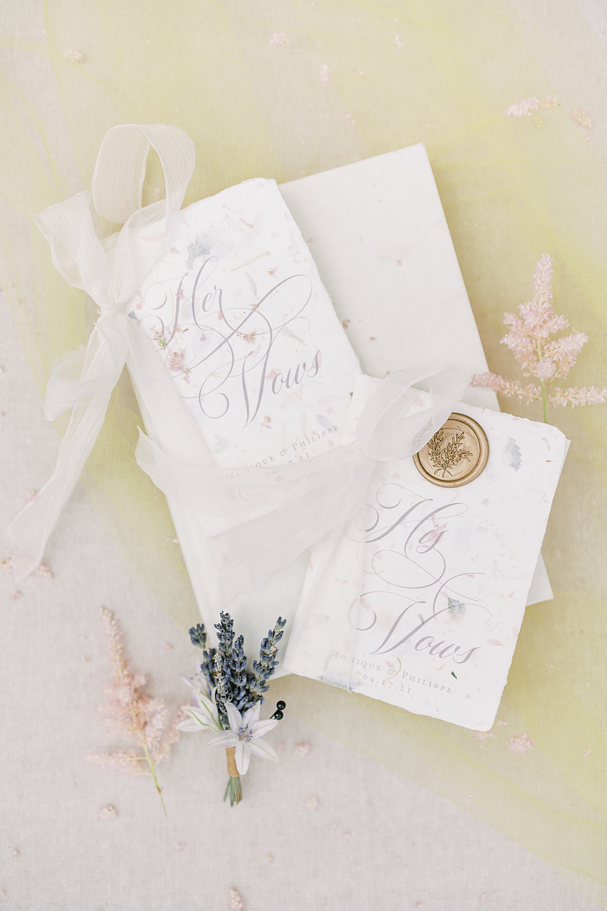 The couple's vow books stamped with a wax seal and a small bushel of lavender 