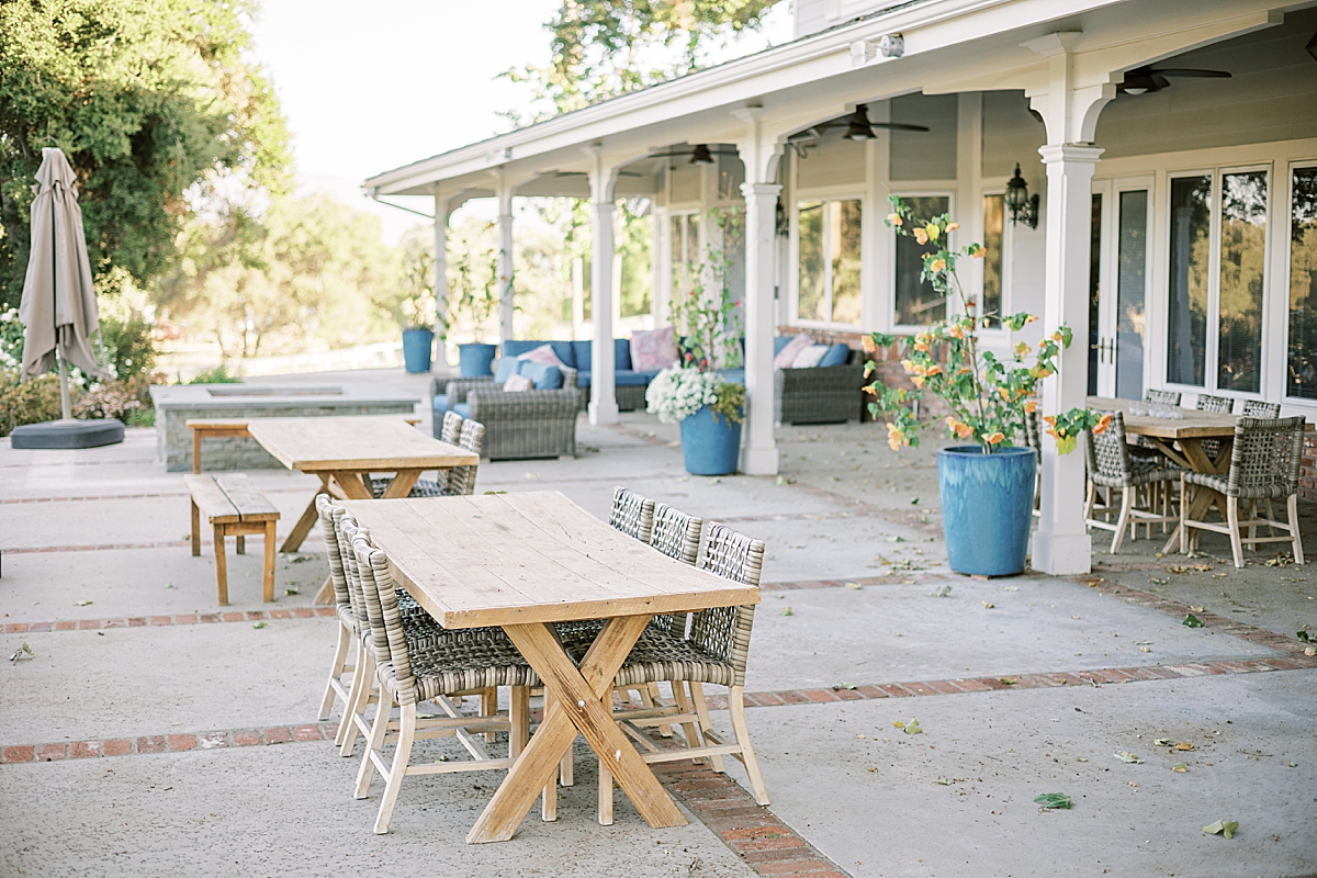 tables with chairs and a large fireplace are staples on the patio of the farmhouse at this Roblar Farm wedding venue.