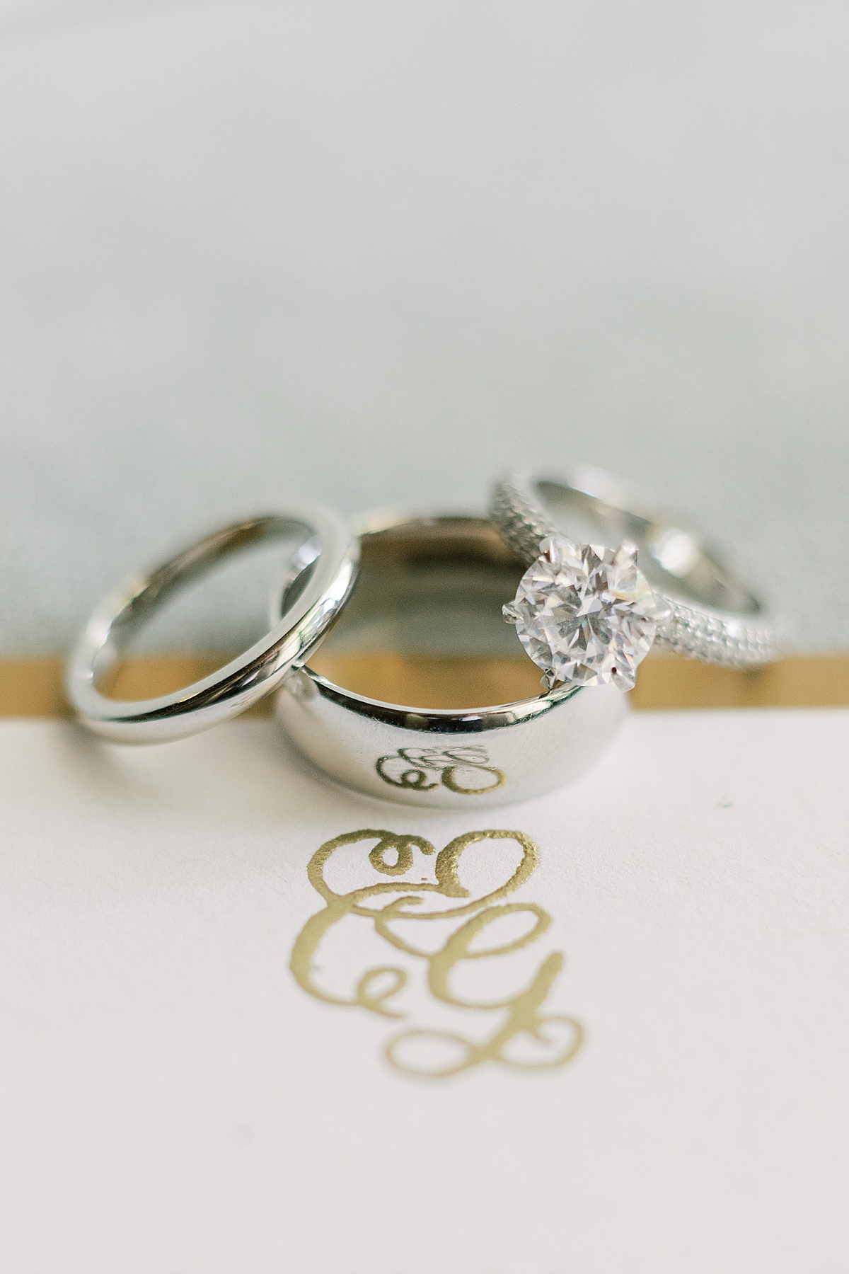 The couple's rings next to the insignia of their wedding invitation